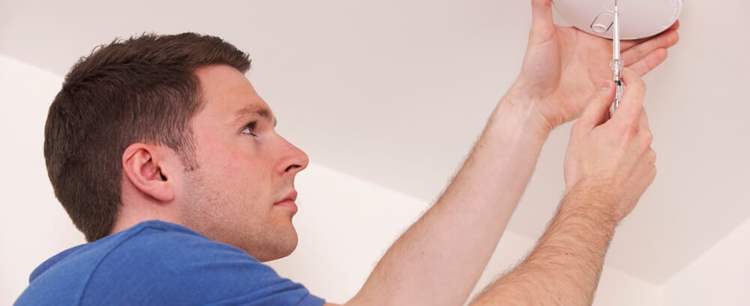 an image of a technician installing a carbon monoxide alarm as Call for carbon monoxide alarms to be fitted in all let homes