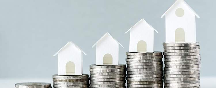 Models of houses on top of coins to show Mortgage Approvals