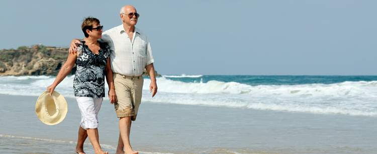 Couple walking on the beach near their mobile holiday home