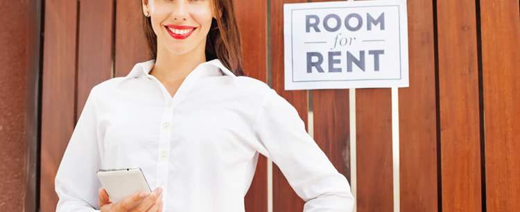 Woman in front of a room for rent sign