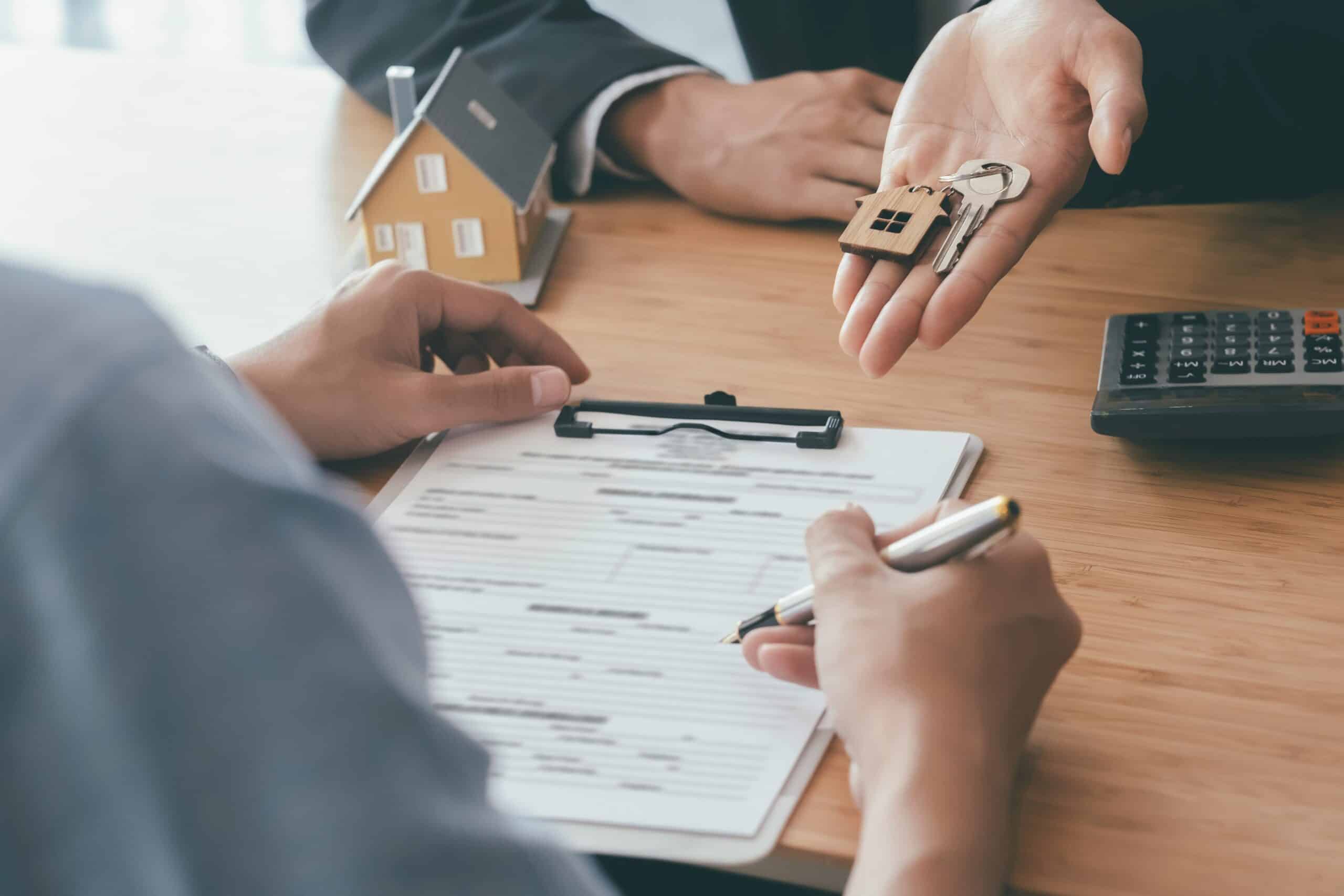 A person handing over a key to another person