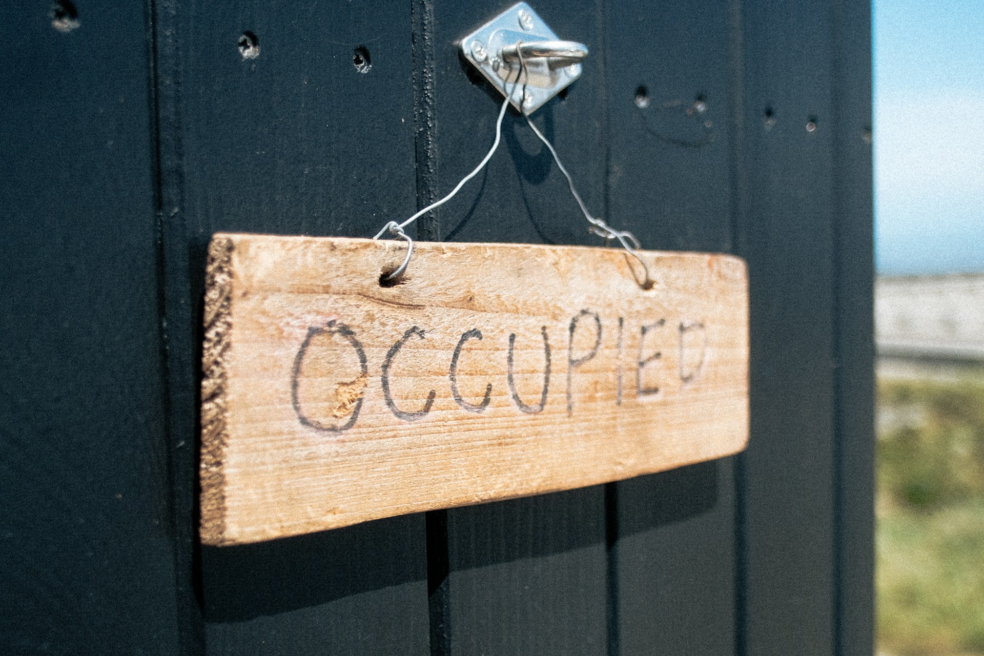 A sign on a black door that says "Occupied"